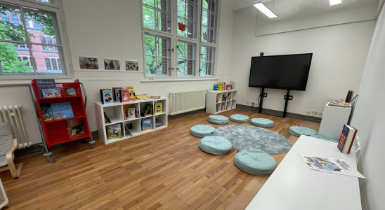 Sprachbibliothek in der Nürtingen Grundschule - Sitzkreis mit Bücherregalen und Smartboard